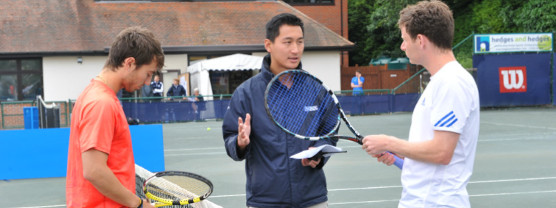 A tennis coach teaching tactics to tennis players