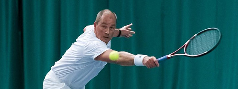 Tennis player reaching for a backhand