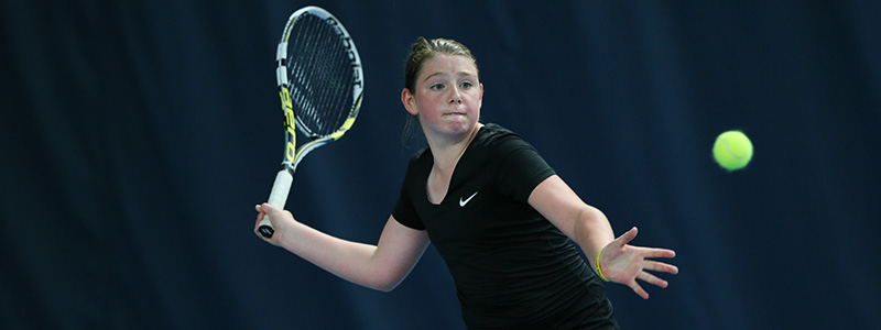 A girl prepares to hit a tennis forehand
