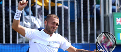 Dan Evans smiles at the Surbiton Trophy as he progresses to the final 